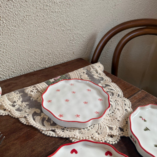 Bord met bloemmotief en rode rand