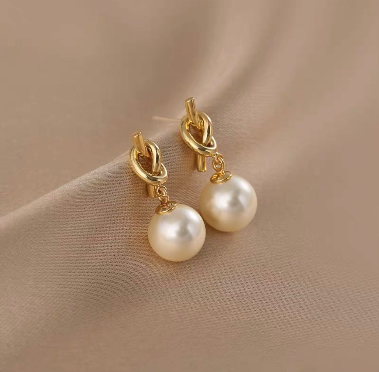 Oorbellen met knoop- en pareldesign